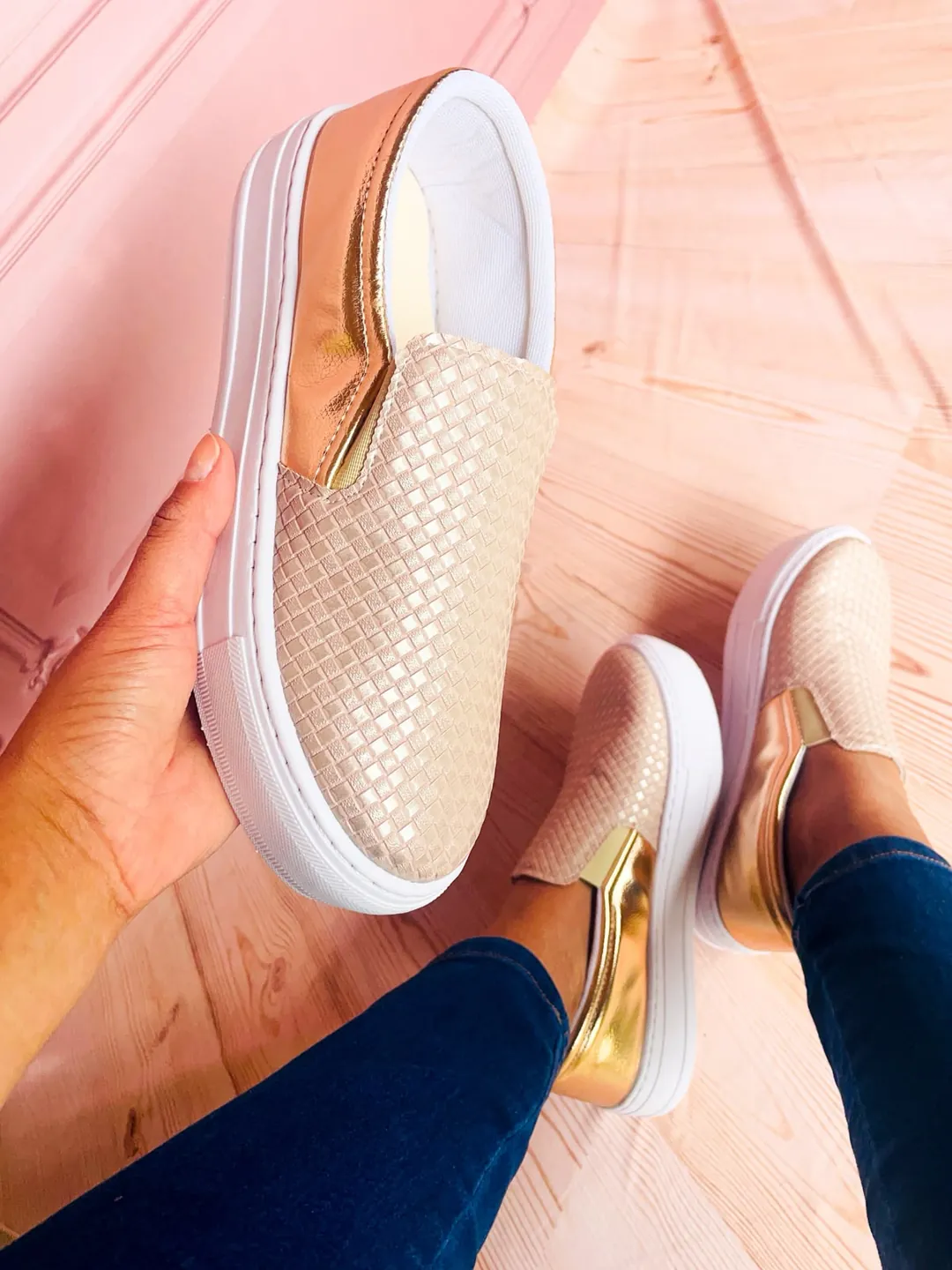 Mão segurando o Slip-on Trançado Champagne, mostrando o calcanhar dourado